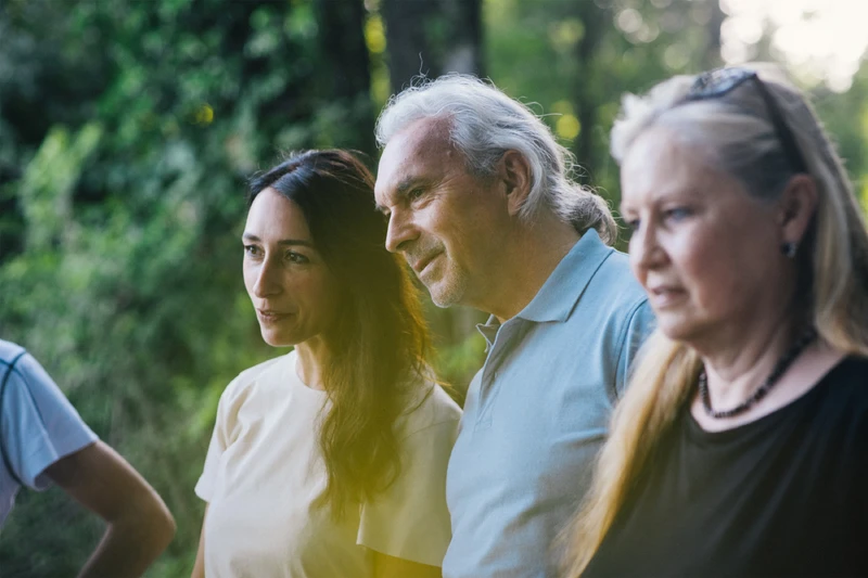 Eine Gruppe von Menschen stehen draußen und hören zu