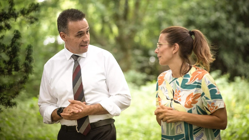 Zwei Personen spazieren draußen und unterhalten sich.