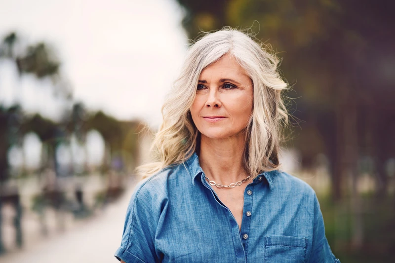 Frau steht draueßn und schaut in die Ferne